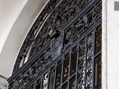 Qui si trova una nicchia ad arco protetta da una cancellata in ferro...